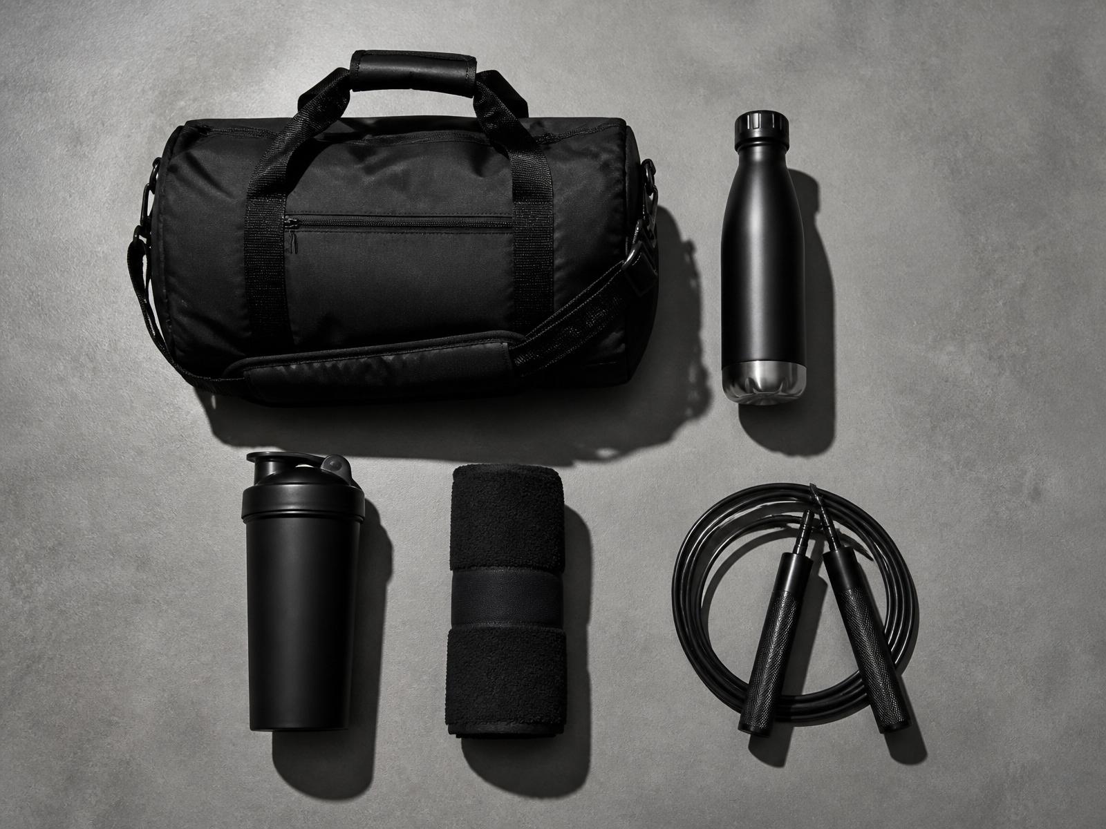 Flat lay of matte black gym gear on concrete